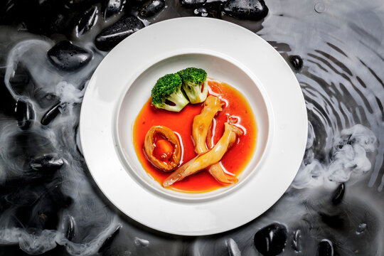 Abalone and fish maw in abalone sauce are placed in water surrounded by dry ice.
