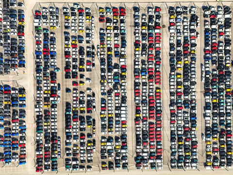 Aerial view of hundreds of colorful cars parked in neat rows at a large logistics hub or factory lot Rivalta di Torino, Piedmont, Italy.