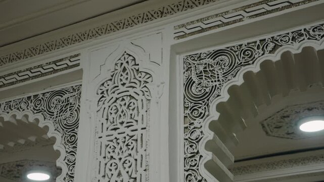 Close up of intricate Moroccan architectural details. White plaster carvings create a beautiful pattern in a traditional Moroccan riad. This serene and elegant space evokes