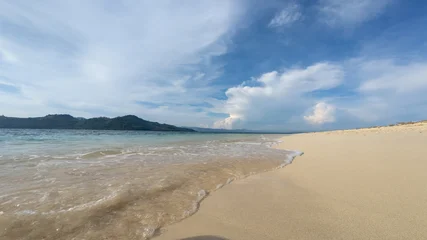 Fototapeten Tropischer Strand Sandy Beach and Turquoise Water Under Cloudy Sky  © Palugada