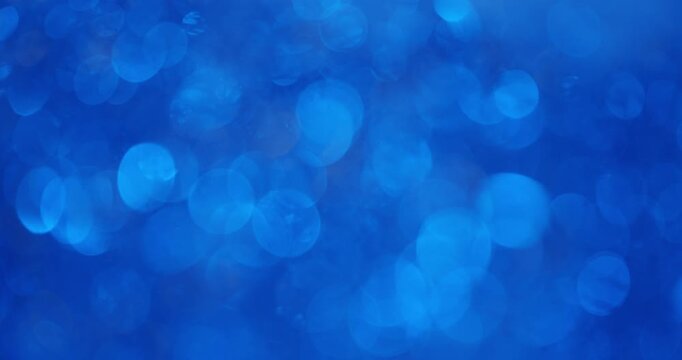 Blue glitter background with sparkling and shimmering bokeh particles creating a magical and festive abstract texture, perfect for holiday celebrations, overlays, and stylish presentations