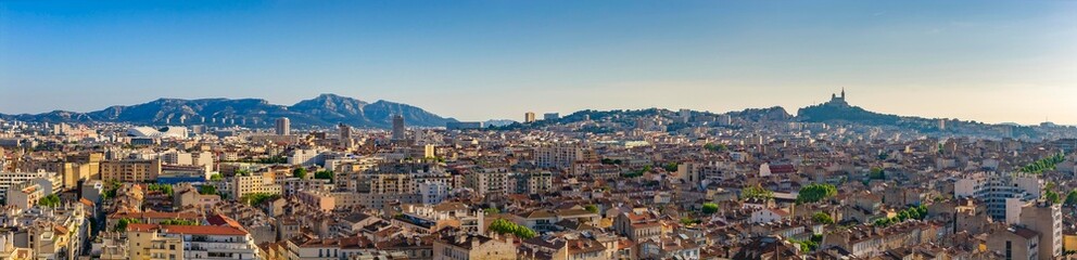Vue aérienne panoramique de Marseille, Notre Dame de la Garde, les collines et le stade © Lino Curiantis