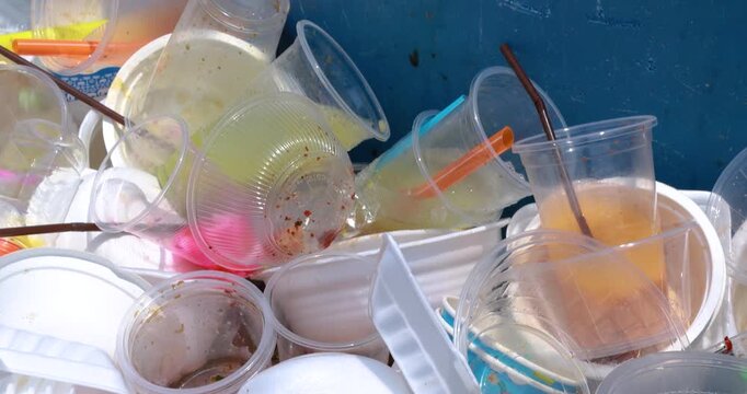 Plastic waste pile including cups and foam containers, Garbage pile, Plastic waste, Pollution, Waste management issues, and environmental impact, close-up