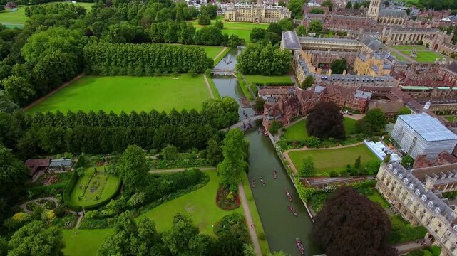 4K aerial view of Cambridge University with Trinity College, St John's College, manicured gardens and traditional punts on the River Cam along The Backs in summer.