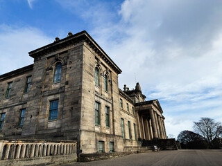 Obraz premium Historic neoclassical Modern Two Dean Gallery building in Edinburgh Scotland UK with stone facade and grand columns and people sitting on benches under a dramatic sky