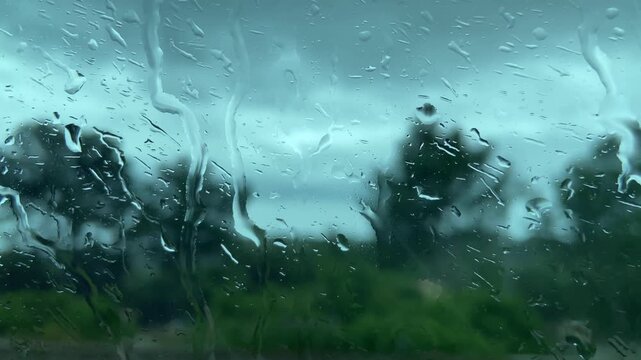 Rain. Water, displaced by the oncoming air flow, runs down the glass of a bus window. Mallorca, Spain.