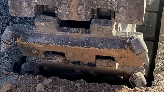 A close-up of a trench excavator's chain-and-scraper attachment in action. 0.9x speed. Mallorca, Spain.