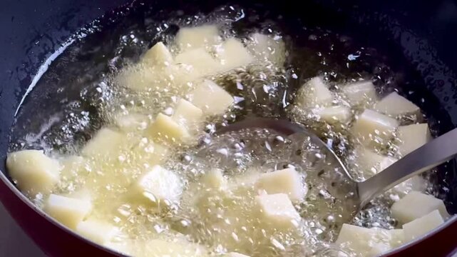 Diced potatoes frying in hot boiling oil