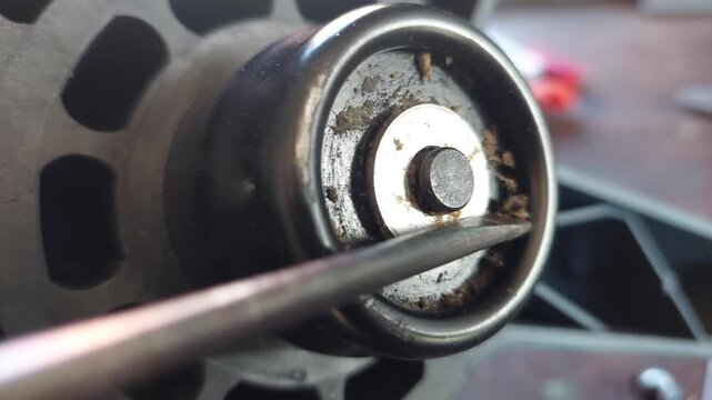Detail of cleaning bread maker machine shaft with a screwdriver