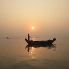 Obraz premium Silhouette of a lone fisherman in a small boat on the water at sunrise