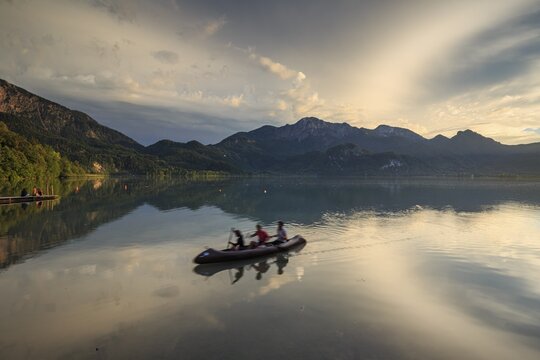 Canoeist on lake in front of mountains, stormy mood, reflection, Lake Kochel, Alpine foothills, Bavaria, Germany