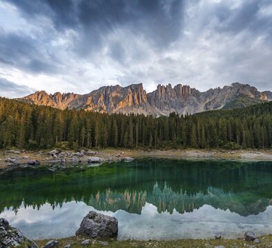 Sunset, dramatic clouds, Latemar group reflected in the Karersee, Diamantidturm, mountain peaks, Eastern Latemarspitze, Col Coron, Lago di Carezza, Welschnofen, Bolzano, South Tyrol, Italy