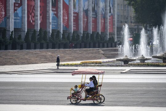 Family in a rickshaw on Ala-Too Square, in Bishkek, Kyrgyzstan