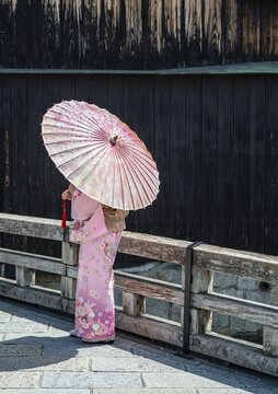 Japanese woman with pink kimono and Japanese parasol, Gion Shirakawa, Kyoto, Japan