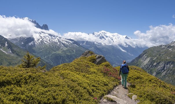 Hiker on a hiking trail to the Aiguilette des Posettes, summit of the Aiguille du Midi and Mont Blanc, Chamonix, Haute-Savoie, France