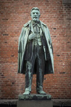 Bronze statue of Carl Jacobsen, Danish brewery entrepreneur, art collector and benefactor, in front of brick wall on plinth, Carlsberg district, Copenhagen, Denmark