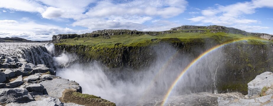 Woman standing in front of gorge, canyon with falling water masses, Dettifoss waterfall in summer, North Iceland, Iceland