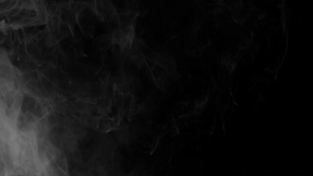 Realistic white smoke cloud billowing slowly across a dark black background.