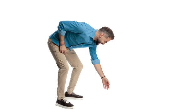Happy man reaching down to pick something up