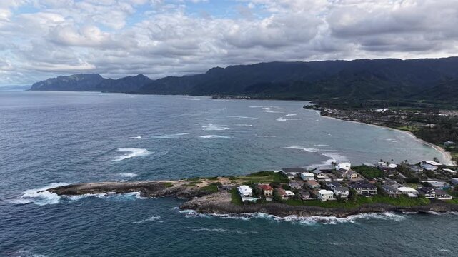 Aerial view of home along Laie Point and the Koolau mountain range in the background in northeastern Oahu in Hawaii. v