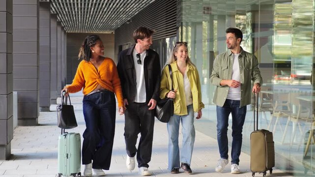 A lively group of friends enthusiastically walking together while pulling their luggage, showcasing the joy of travel and exploration during their memorable trip filled with shared experiences.