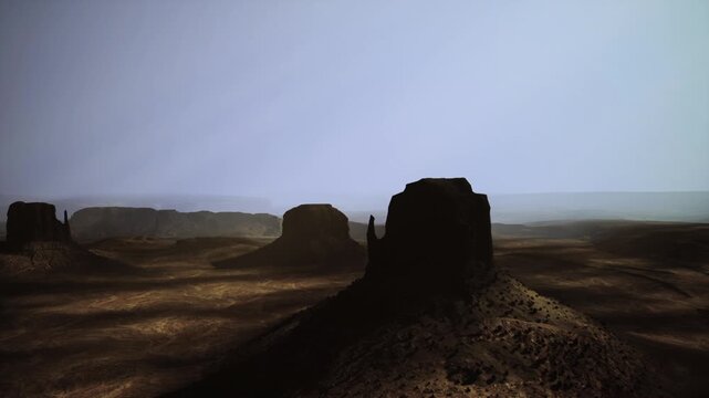 Twilight silhouette of mesas and butte, deep contrast between cool sky and shadowed terrain, crisp ridgelines, cinematic stillness, remote wilderness vibes,