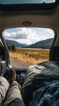 Blick aus dem Campervan auf Berglandschaft und Natur &ndash; gem&uuml;tliche Vanlife-Szene mit Bett im Wohnmobil, Freiheit und Abenteuergef&uuml;hl. Viel copyspace und copy space.