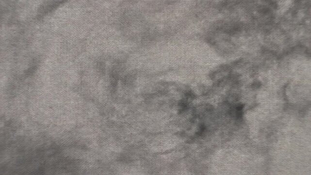 An abstract, textured pattern showcasing swirling wisps of dark gray and lighter charcoal elements against a subtly interwoven, canvas-like surface, evoking a sense of dramatic, ethereal mist