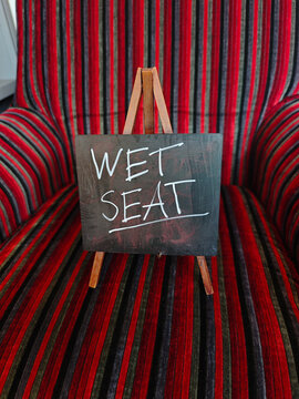 Wet seat sign on stripey chair