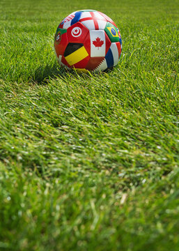 green grass texture and soccer ball flags of the countries - well-groomed turf in the garden. Poster with copy space.