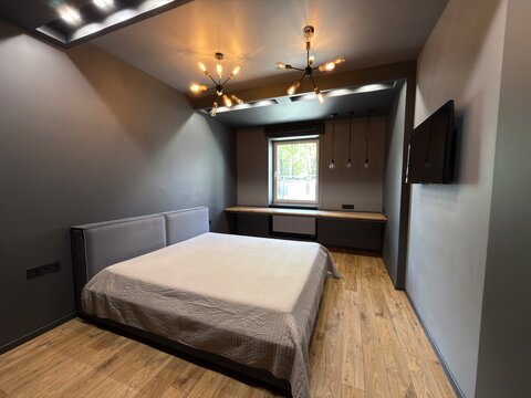 Modern dark bedroom interior with industrial lighting and wooden floor