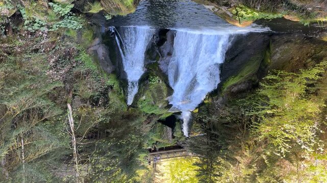 Triberg, Germany - May 1, 2026: Visitors walk above the Triberg Waterfalls in the Black Forest during spring. Flowing waterfall surrounded by forest and rocks.