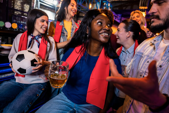 Sports fans cheering loudly during live match in bar