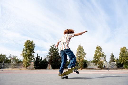 Urban skater practicing balance tricks on outdoor court