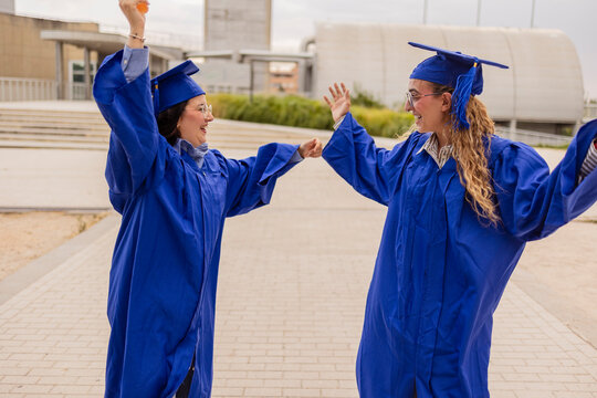 Young women students celebrate graduation in blue gowns