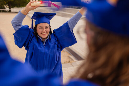 Joyful female student celebrating graduation with diploma