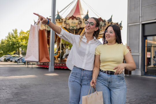 Two female friends shopping and exploring a city fair