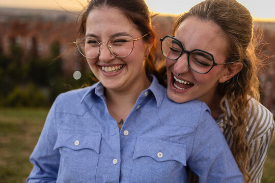 Two women friends laughing together outdoors in Madrid