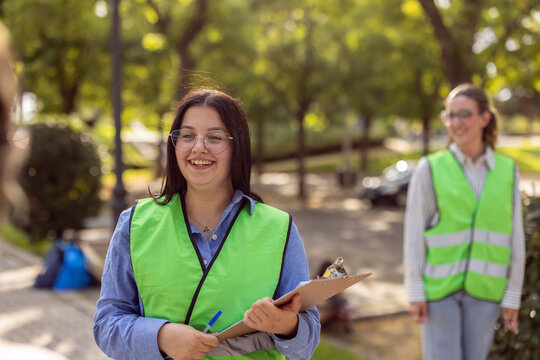 Women volunteers in safety vests doing park cleanup work