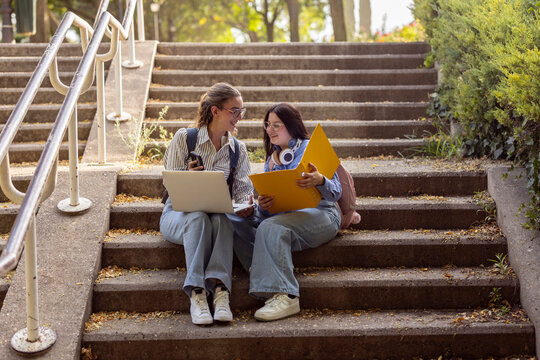 Female students studying together on outdoor campus stairs