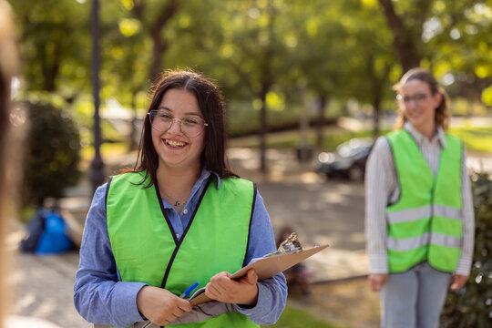 Women volunteers in safety vests doing park cleanup work
