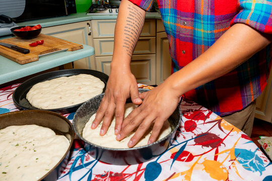 Hands shaping sourdough focaccia dough in home kitchen