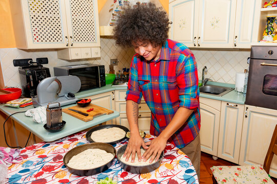 Home baker pressing sourdough focaccia dough in kitchen