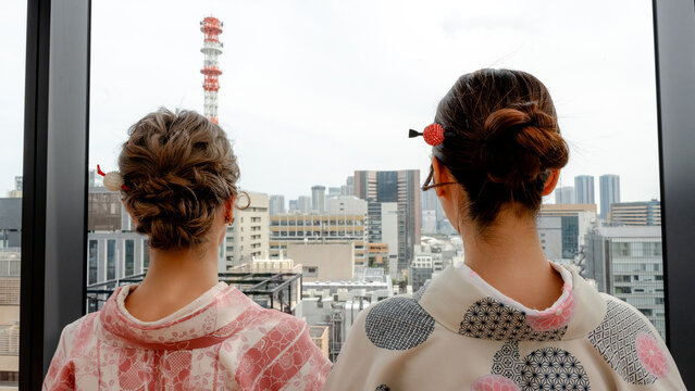 Japanese women in kimono overlook Tokyo city skyline view