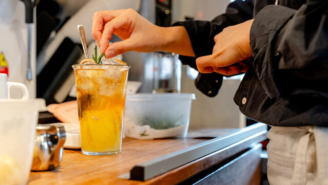 Barista crafting a refreshing iced beverage in a cafe