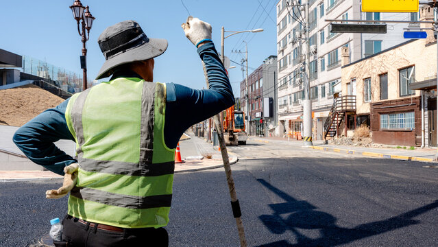Workers paving street with fresh asphalt in urban area