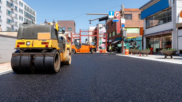 Workers improving road conditions with asphalt paving
