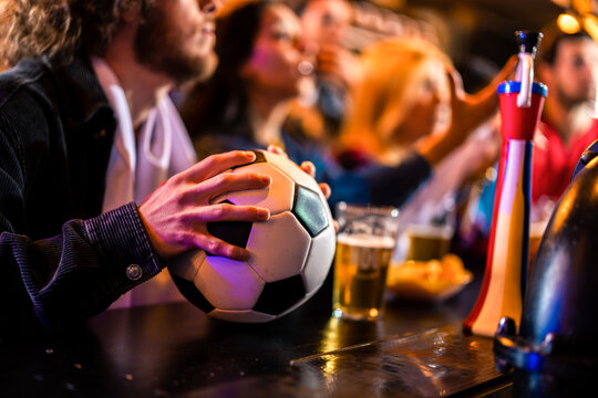 Energetic group of friends cheering during live soccer match in pub