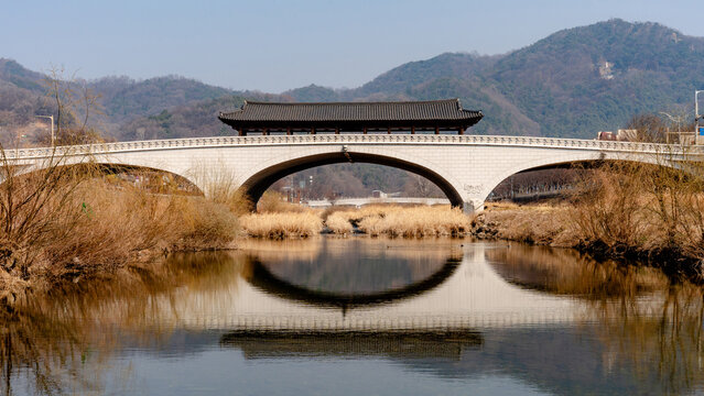 Namcheongyo Bridge reflecting over calm river and mountains