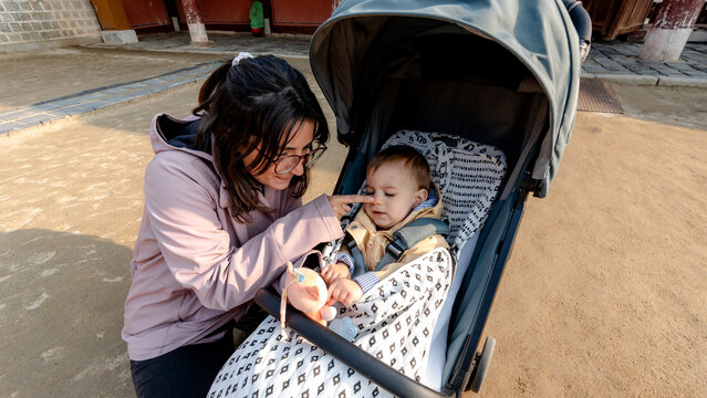 Mother caring for baby in stroller during family travel